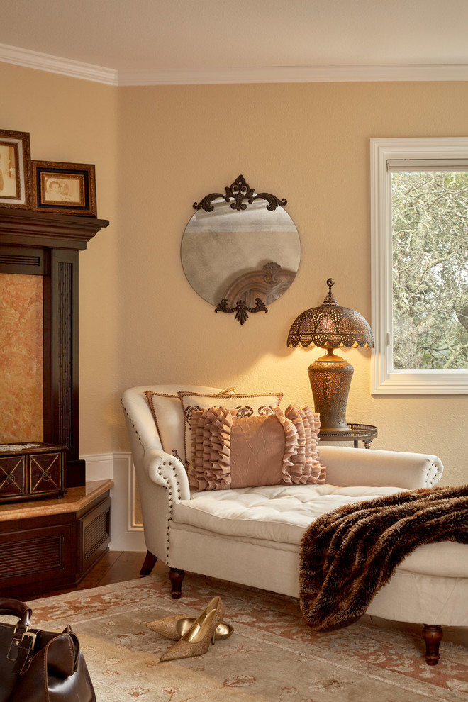 Idées déco pour une chambre classique avec un mur beige, un sol en bois brun, une cheminée standard et un sol marron.