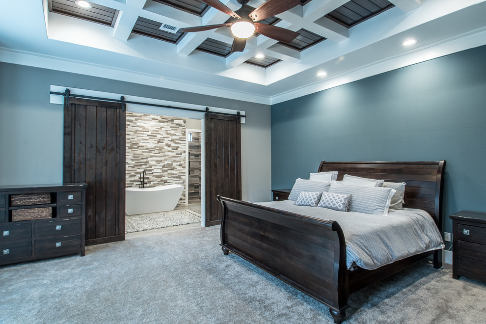Cette image montre une grande chambre craftsman avec un mur bleu, aucune cheminée et un sol gris.