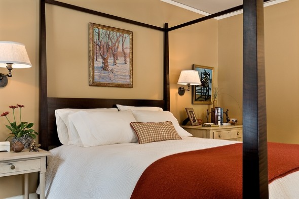 Ejemplo de habitación de invitados tradicional extra grande sin chimenea con paredes beige, suelo de madera oscura y suelo marrón
