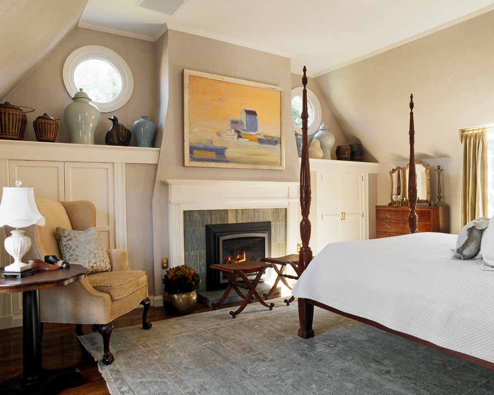 Cette photo montre une chambre chic avec un mur gris et un manteau de cheminée en pierre.