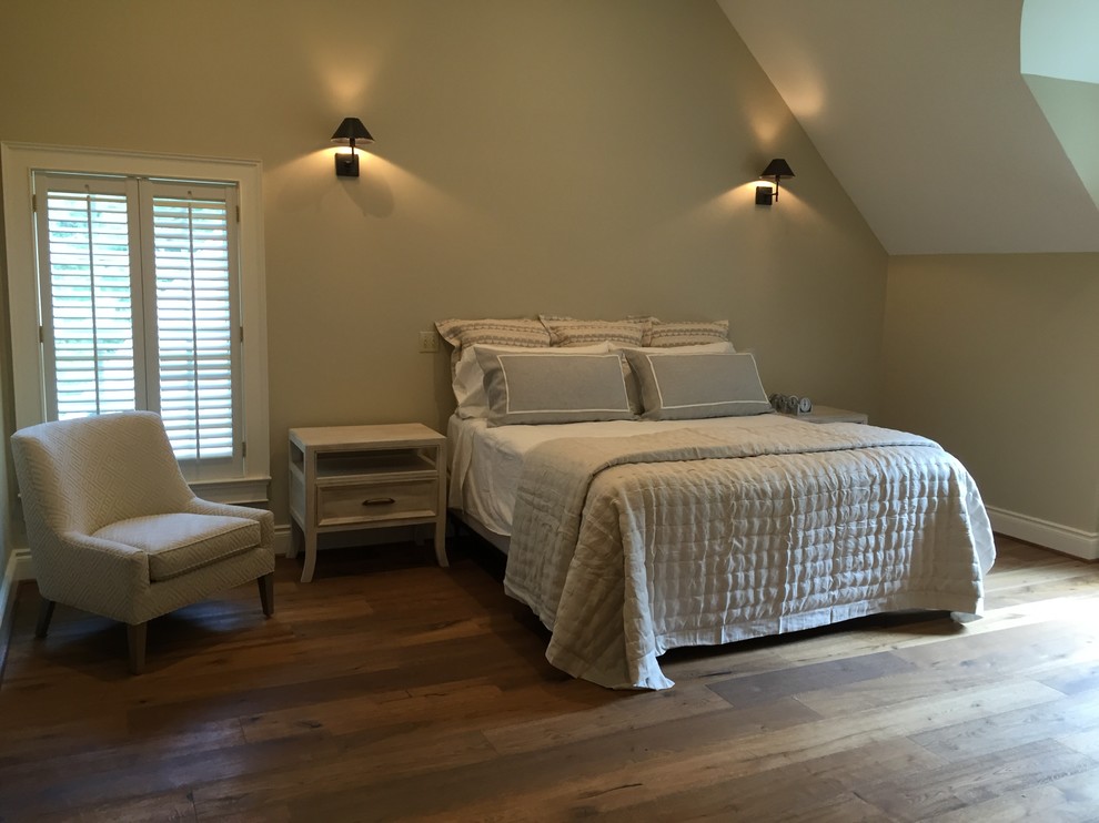 Aménagement d'une grande chambre parentale classique avec un mur beige, un sol en bois brun, un manteau de cheminée en pierre et un sol marron.