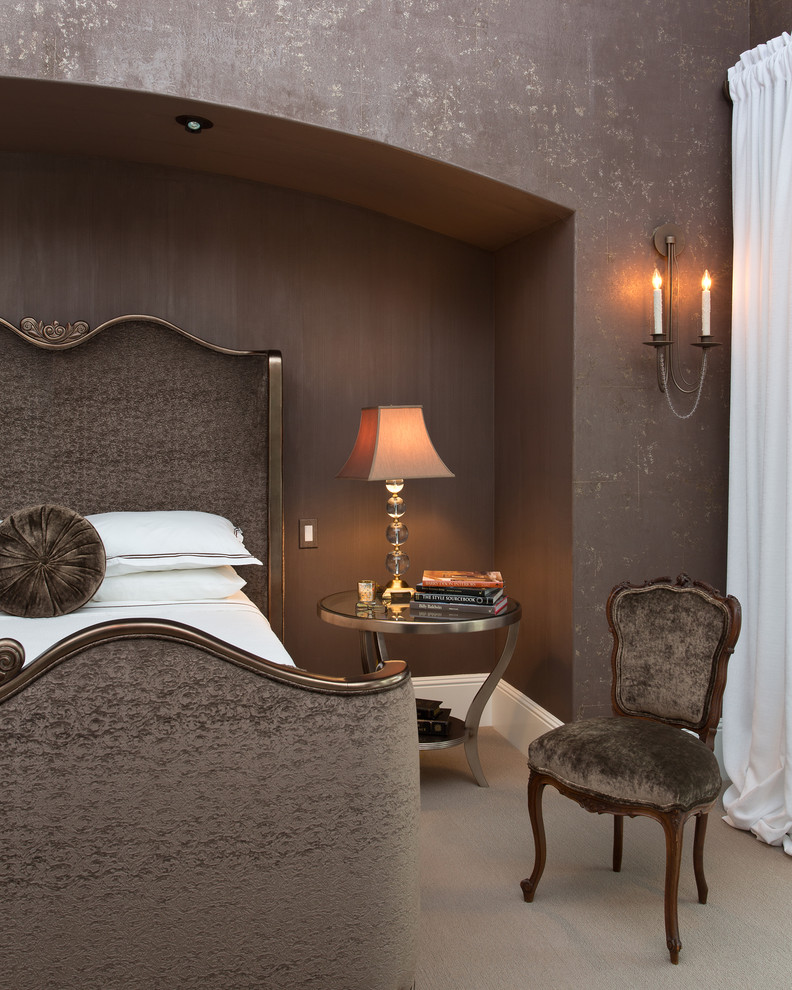 Стильный дизайн: большая хозяйская спальня в классическом стиле с коричневыми стенами, ковровым покрытием, стандартным камином, фасадом камина из штукатурки, бежевым полом и кроватью в нише - последний тренд