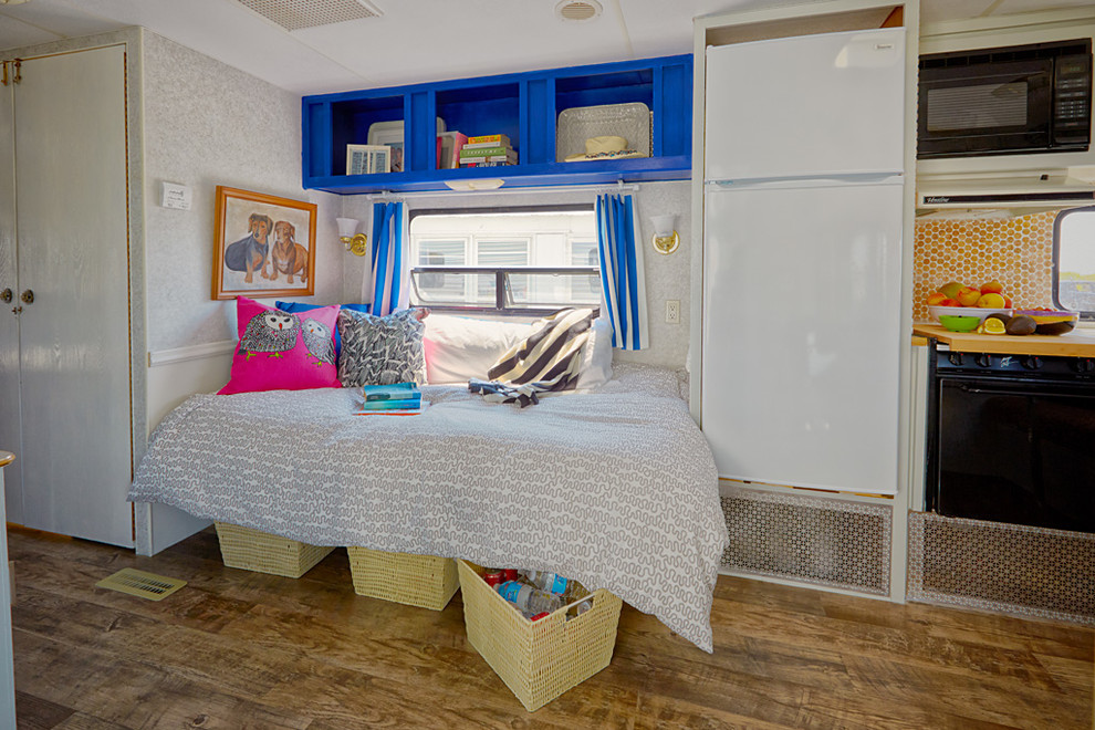 Small bohemian bedroom in Philadelphia with multi-coloured walls, medium hardwood flooring and no fireplace.