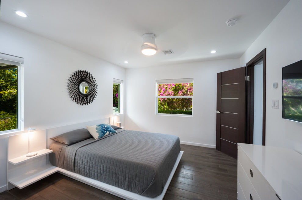他の地域にある中くらいなモダンスタイルのおしゃれな客用寝室 (白い壁、磁器タイルの床) のレイアウト