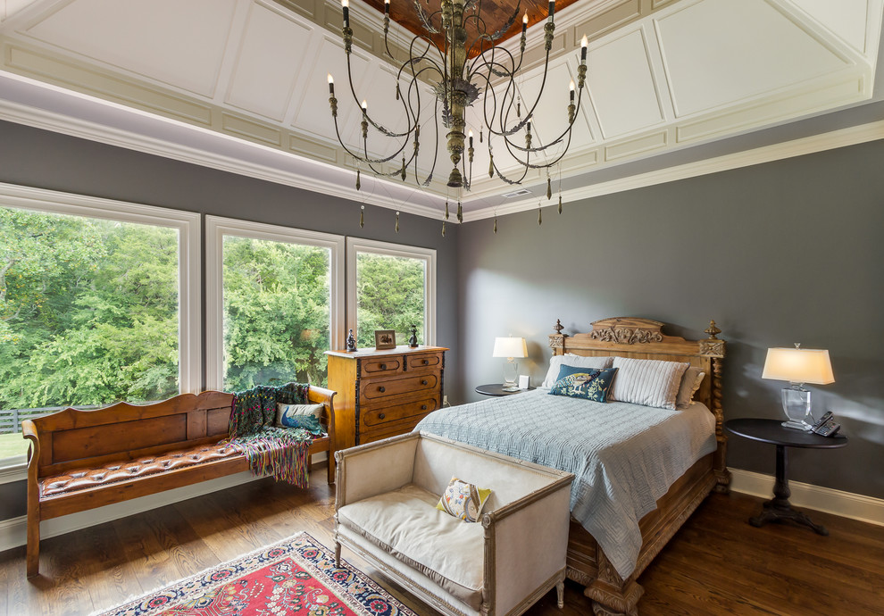Cette photo montre une chambre chic avec un mur gris, un sol en bois brun et aucune cheminée.