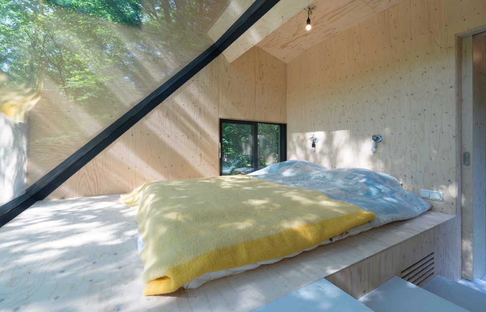 Kleines Modernes Hauptschlafzimmer mit Sperrholzboden in Amsterdam