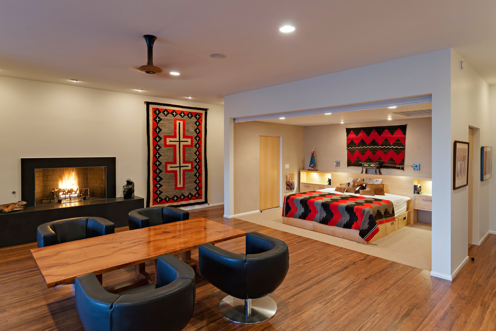 フェニックスにある広いコンテンポラリースタイルのおしゃれな主寝室 (竹フローリング、標準型暖炉、ベージュの壁、石材の暖炉まわり、茶色い床) のインテリア