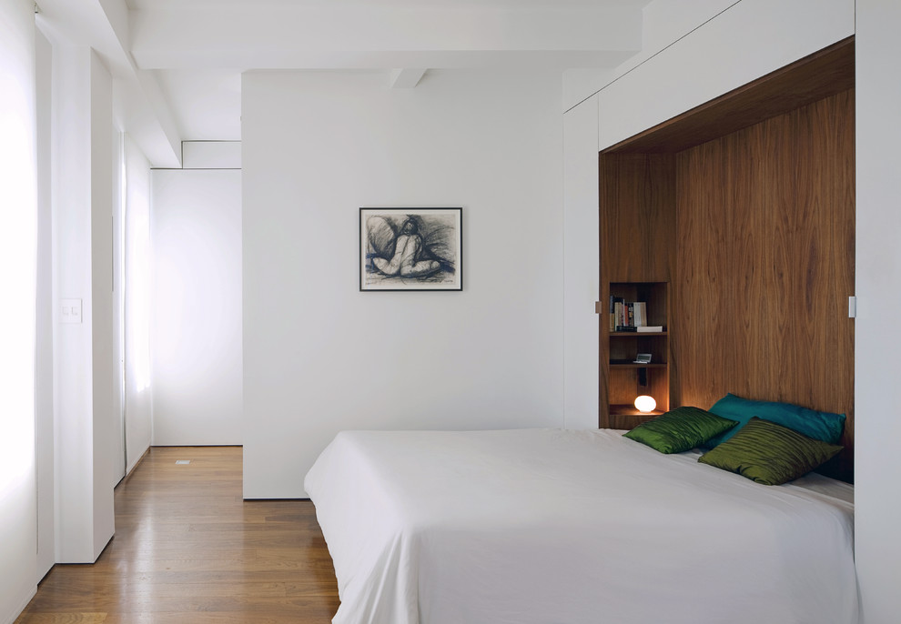 Стильный дизайн: спальня в стиле модернизм с белыми стенами и кроватью в нише - последний тренд