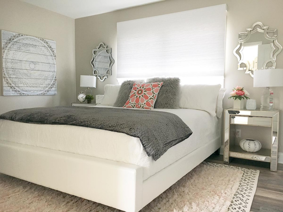 Imagen de habitación de invitados moderna de tamaño medio con paredes grises, suelo laminado y suelo gris