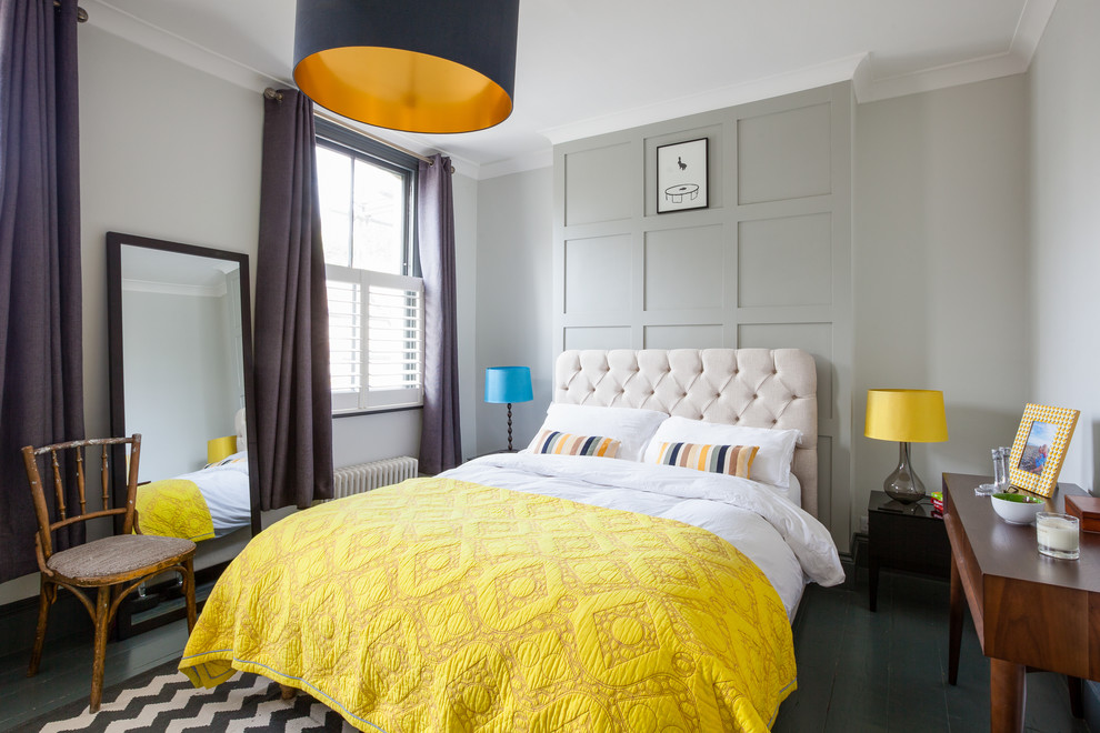 Medium sized traditional grey and yellow bedroom in London with grey walls, painted wood flooring, black floors, no fireplace and feature lighting.