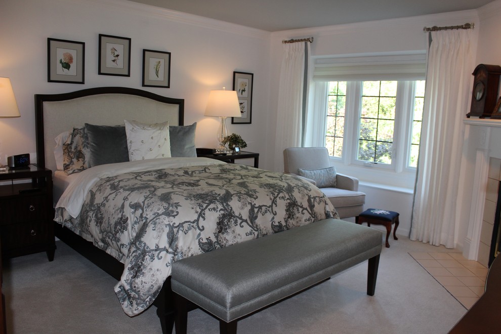 デトロイトにある中くらいなトランジショナルスタイルのおしゃれな主寝室 (白い壁、カーペット敷き、コーナー設置型暖炉、タイルの暖炉まわり、ベージュの床)