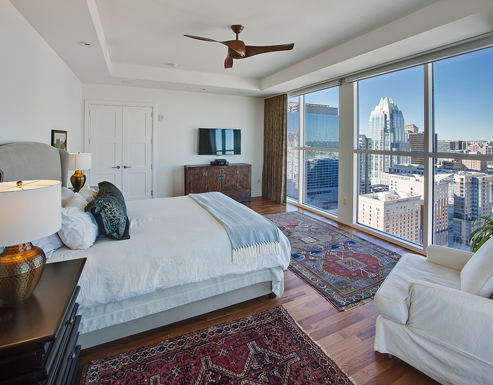 Klassisches Hauptschlafzimmer ohne Kamin mit weißer Wandfarbe und braunem Holzboden in Austin