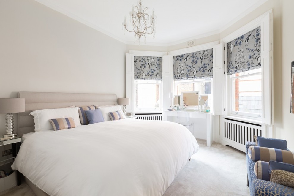 This is an example of a classic master bedroom in London with beige walls and carpet.