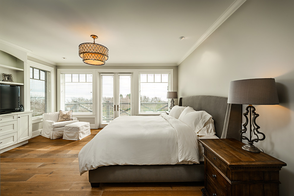 Klassisches Schlafzimmer ohne Kamin mit grauer Wandfarbe und braunem Holzboden in Vancouver