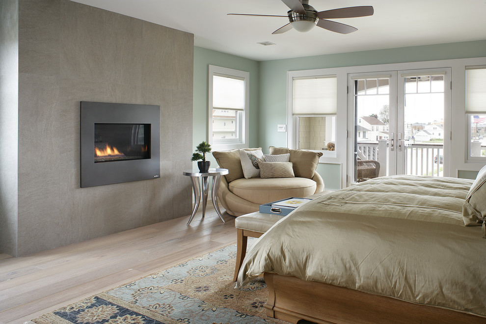 他の地域にある広いトランジショナルスタイルのおしゃれな主寝室 (青い壁、コンクリートの暖炉まわり、標準型暖炉) のレイアウト