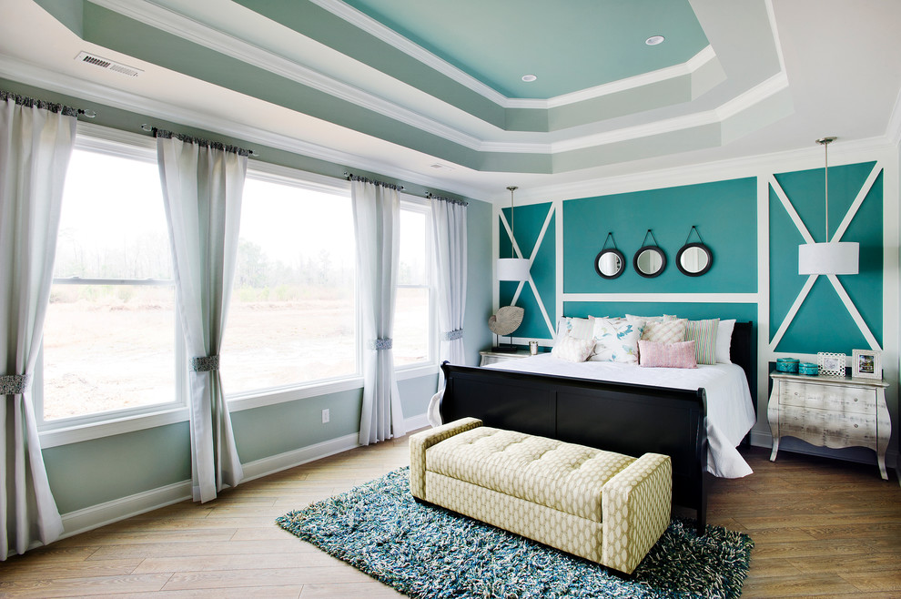Modelo de dormitorio clásico renovado con paredes azules y suelo de madera oscura