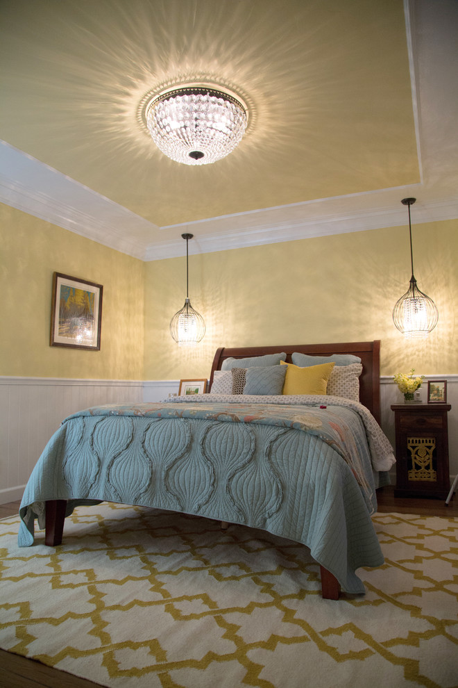 ロサンゼルスにある中くらいなトランジショナルスタイルのおしゃれな主寝室 (黄色い壁、無垢フローリング) のレイアウト