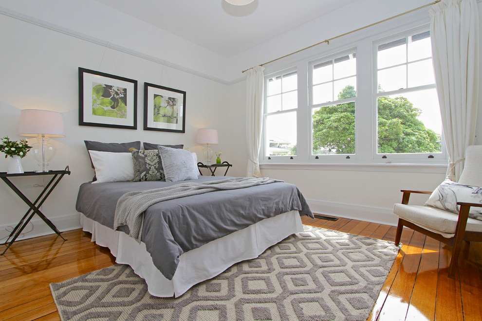 Transitional medium tone wood floor bedroom photo in Hobart with white walls