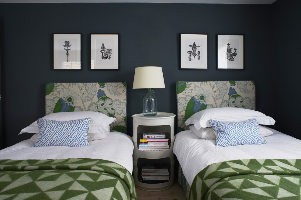 Modelo de habitación de invitados tradicional renovada de tamaño medio sin chimenea con paredes azules y suelo de madera clara