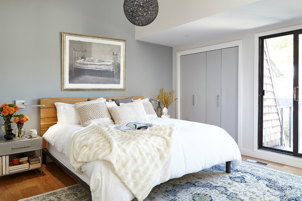 Klassisches Schlafzimmer ohne Kamin mit grauer Wandfarbe und braunem Holzboden in Toronto