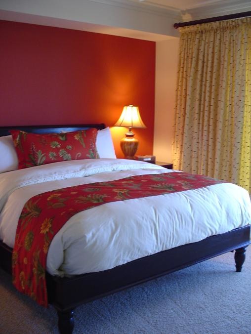 Imagen de habitación de invitados tropical con paredes rojas y moqueta