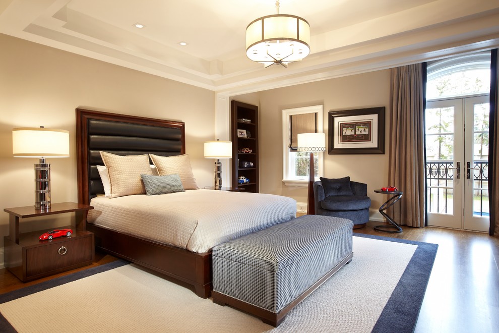 Example of a large transitional guest medium tone wood floor bedroom design in Toronto with beige walls