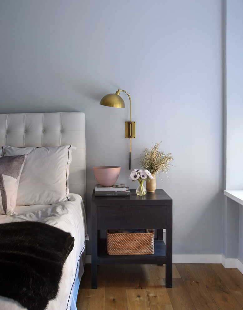 Inspiration pour une grande chambre parentale traditionnelle avec un mur bleu, un sol en bois brun et un sol marron.