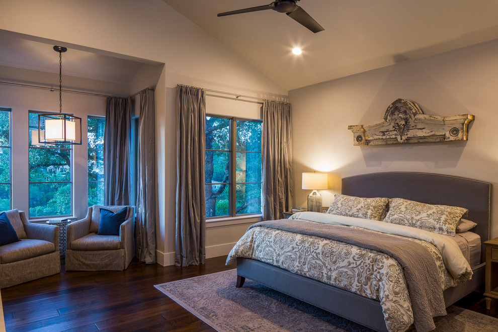 Mittelgroßes Landhausstil Hauptschlafzimmer mit weißer Wandfarbe, dunklem Holzboden, Kamin und Kaminumrandung aus Stein in Austin
