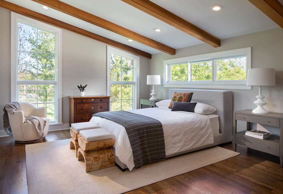 Imagen de dormitorio principal y abovedado tradicional renovado sin chimenea con paredes beige, suelo de madera en tonos medios, suelo marrón y vigas vistas