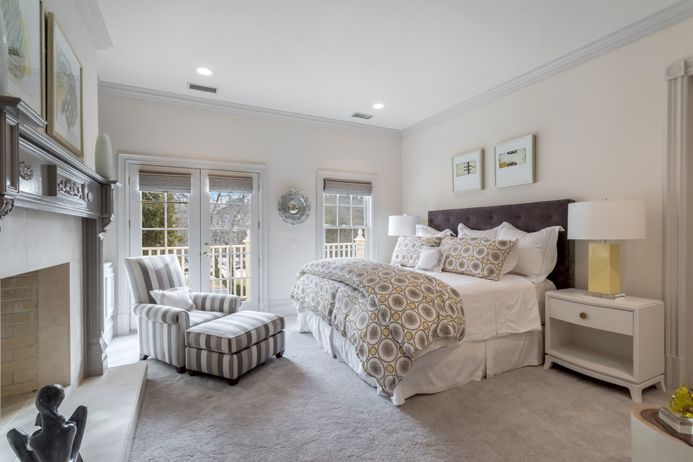 Стильный дизайн: большая хозяйская спальня в стиле неоклассика (современная классика) с серыми стенами, ковровым покрытием, стандартным камином и фасадом камина из камня - последний тренд