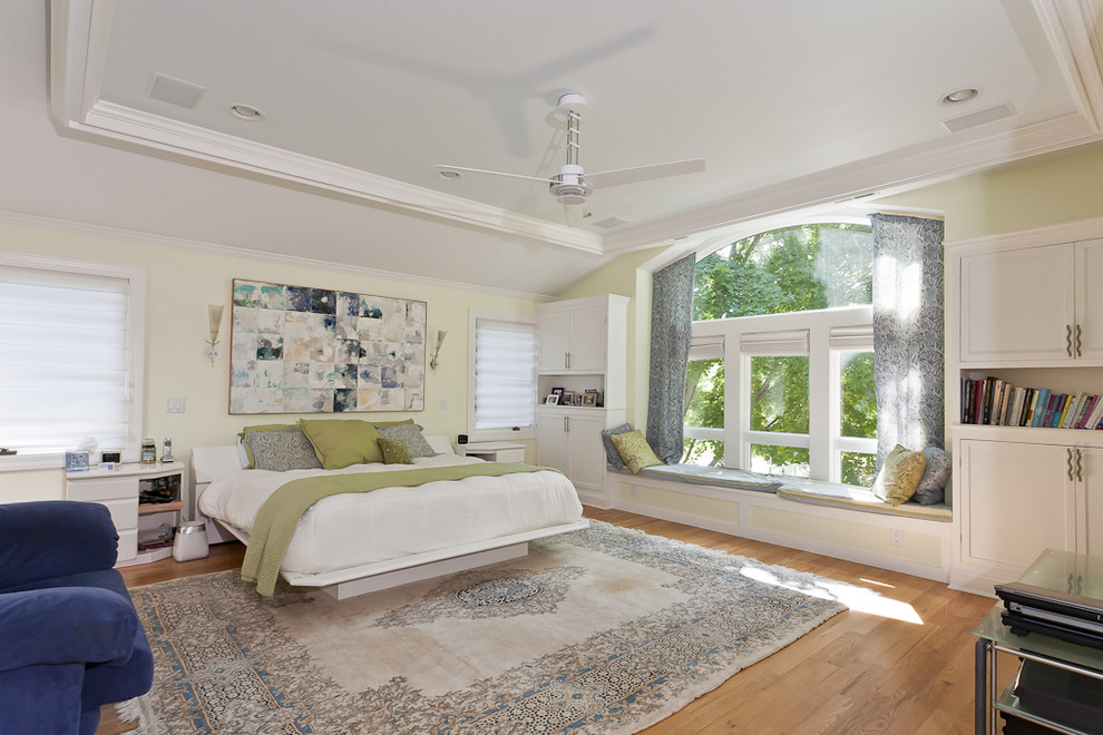 Ejemplo de dormitorio principal tradicional renovado grande con paredes verdes y suelo de madera clara