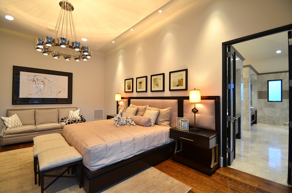Modelo de dormitorio principal contemporáneo grande sin chimenea con paredes beige, suelo de madera en tonos medios y suelo marrón