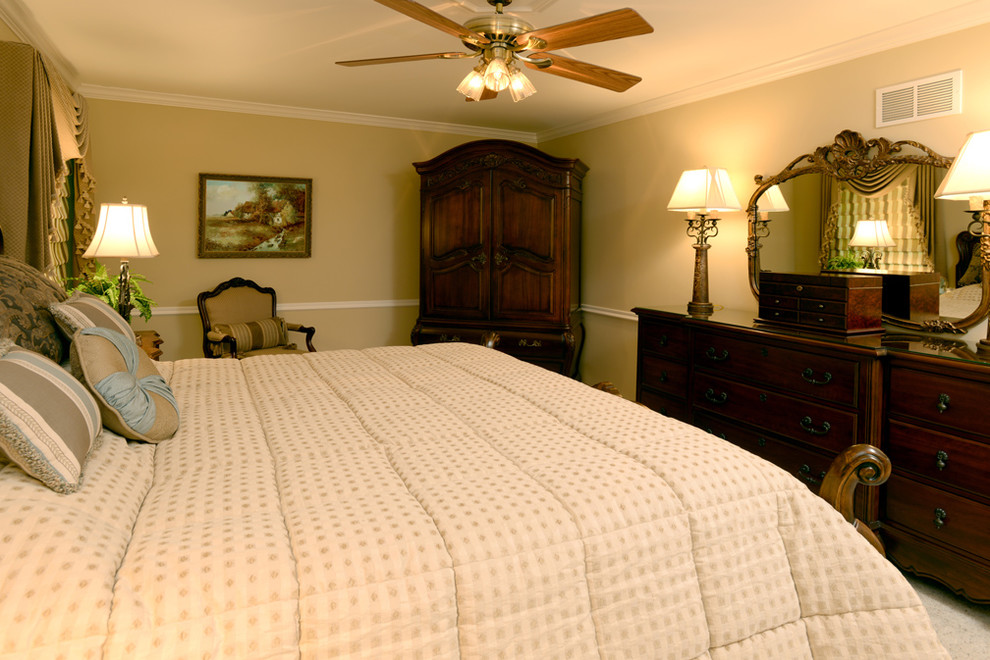 Modelo de dormitorio principal rural de tamaño medio con paredes beige, moqueta y suelo beige