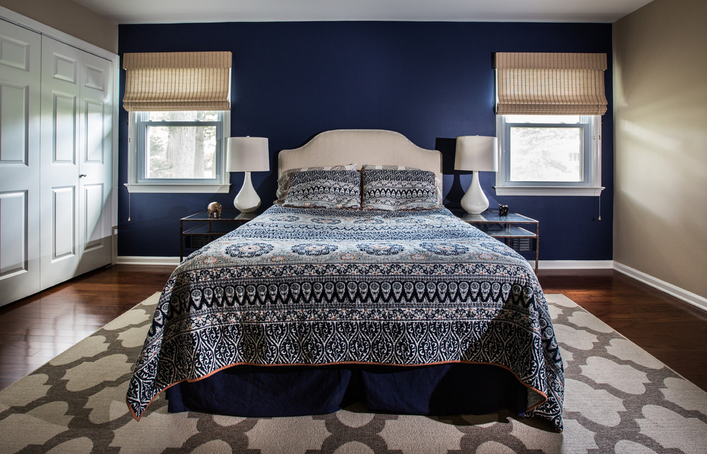 Exemple d'une chambre parentale chic de taille moyenne avec un mur bleu, parquet foncé et un sol marron.