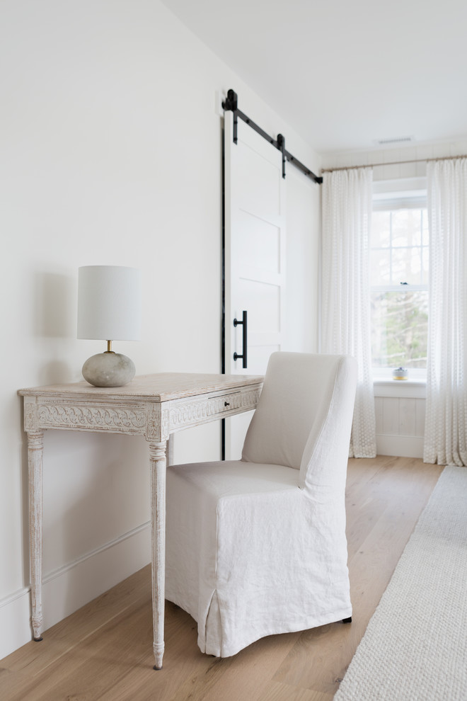 Modelo de habitación de invitados marinera grande con paredes beige, suelo de madera clara y suelo beige