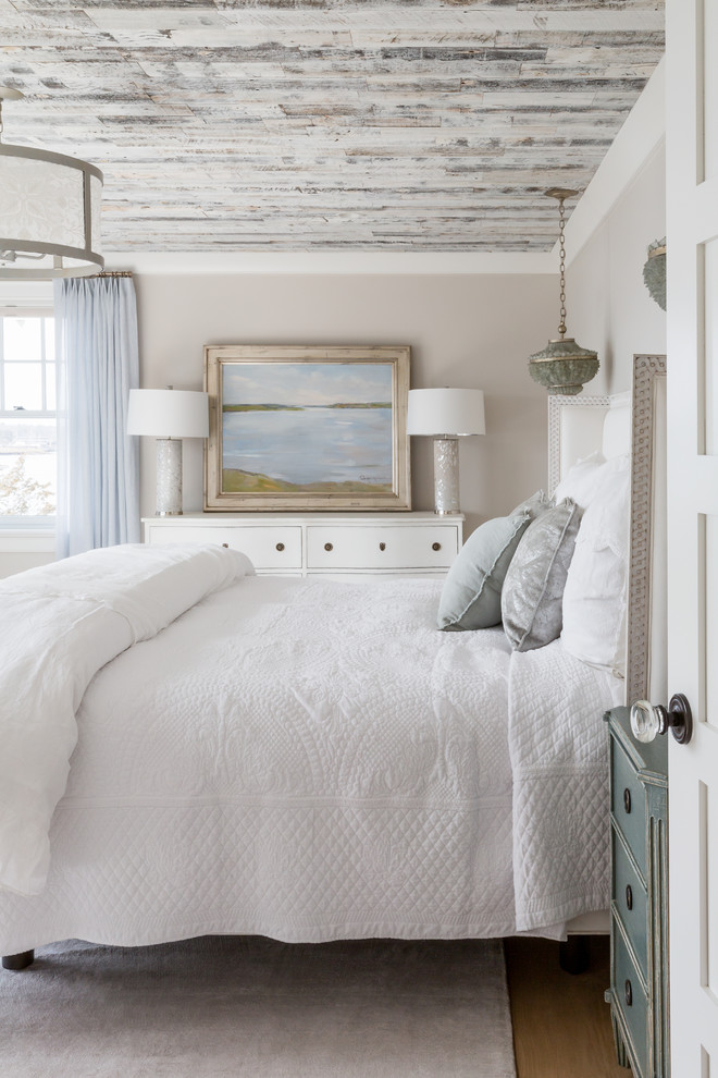 This is an example of a large beach style master bedroom in Boston with beige walls, light hardwood flooring, no fireplace and beige floors.