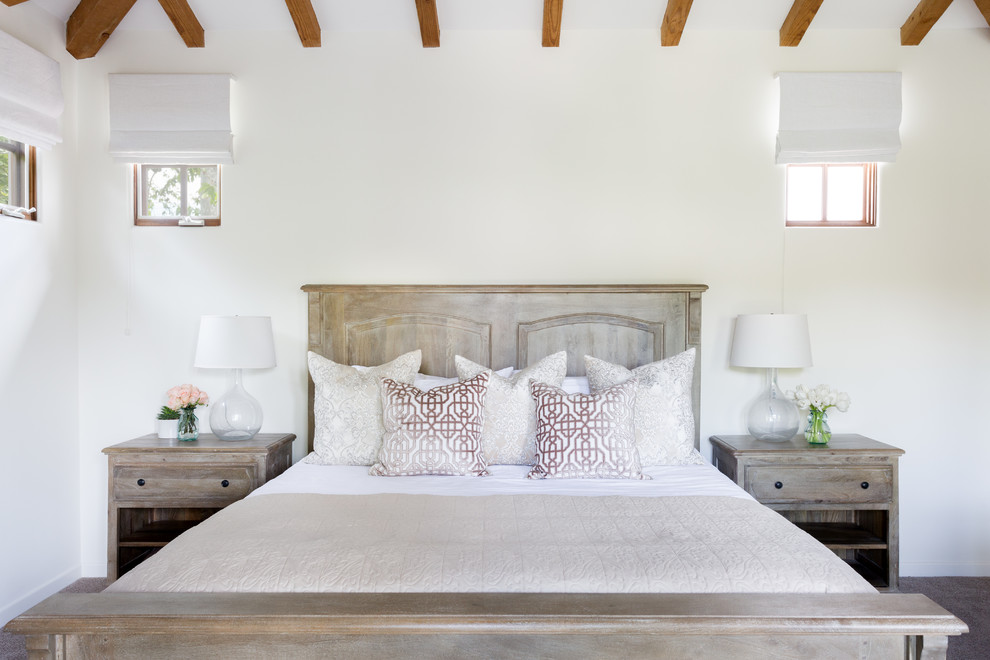 This is an example of a medium sized master bedroom in Los Angeles with white walls, carpet, a corner fireplace, a plastered fireplace surround and grey floors.