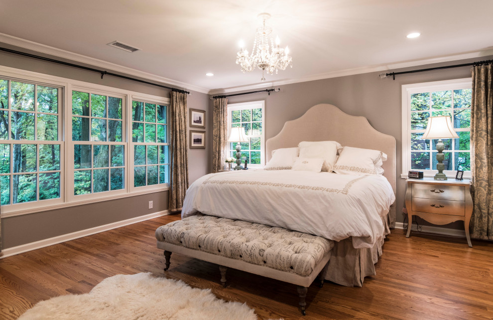 Стильный дизайн: большая хозяйская спальня в стиле неоклассика (современная классика) с серыми стенами, паркетным полом среднего тона, стандартным камином, фасадом камина из плитки и коричневым полом - последний тренд