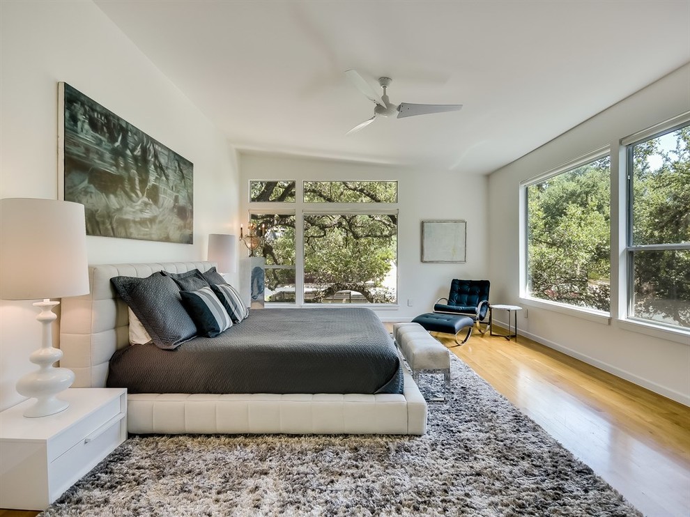Idee per una camera da letto design con pareti bianche, pavimento in legno massello medio e pavimento marrone