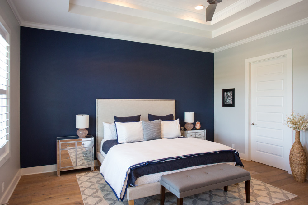 Großes Klassisches Hauptschlafzimmer ohne Kamin mit blauer Wandfarbe, hellem Holzboden und beigem Boden in Austin