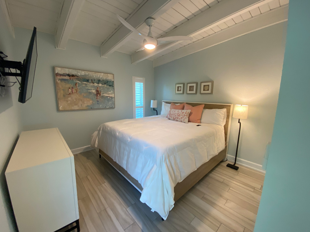 Esempio di una camera matrimoniale stile marino di medie dimensioni con pareti blu, pavimento in gres porcellanato, nessun camino e pavimento beige