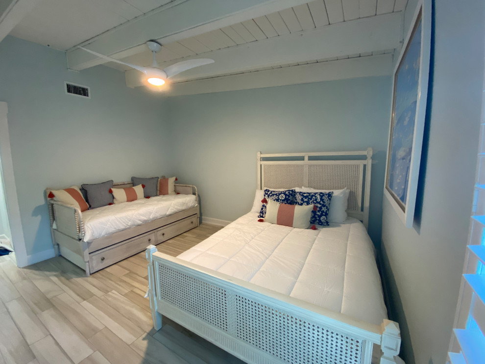Immagine di una camera degli ospiti stile marino di medie dimensioni con pareti blu, pavimento in gres porcellanato, nessun camino e pavimento beige
