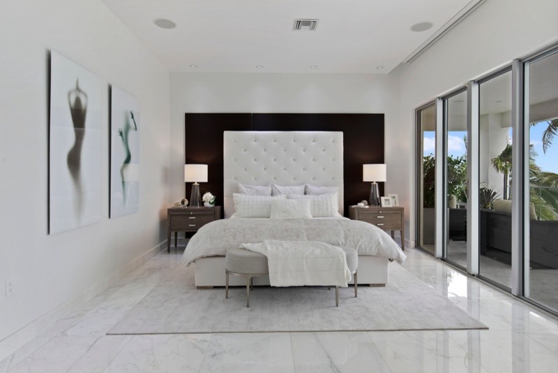 Ejemplo de dormitorio principal actual grande sin chimenea con paredes blancas, suelo de mármol y suelo blanco