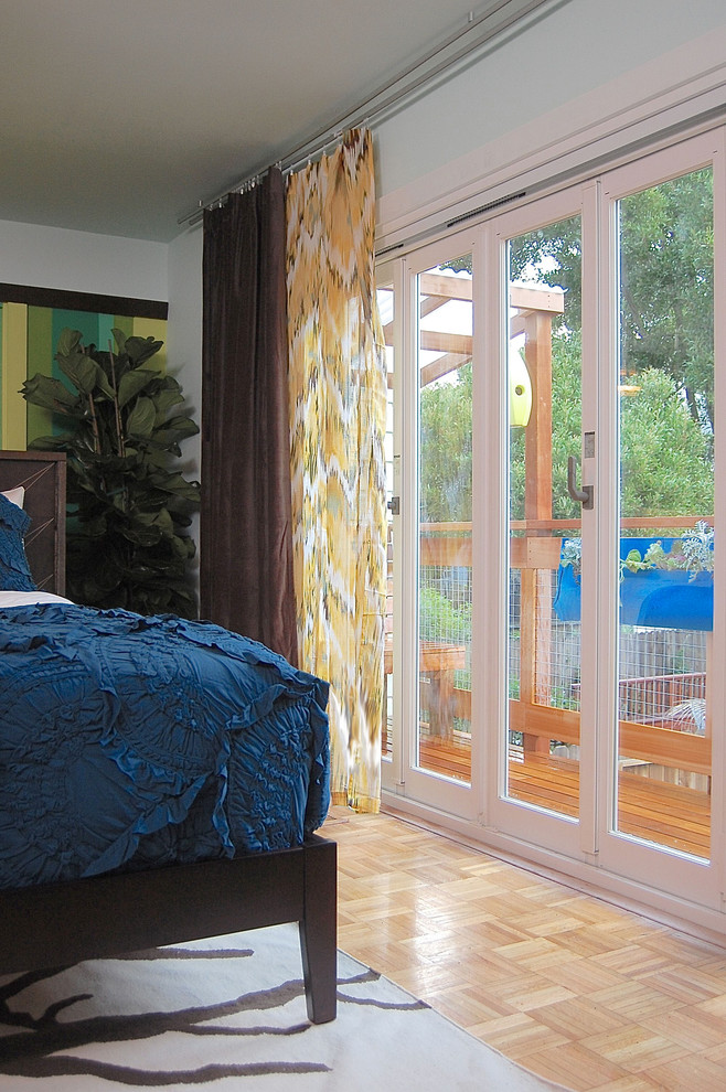 サンフランシスコにある中くらいなコンテンポラリースタイルのおしゃれな主寝室 (青い壁、無垢フローリング、茶色い床)