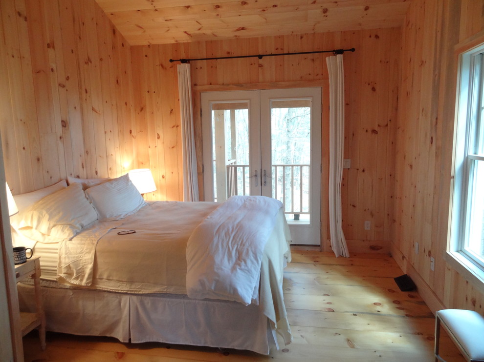 Diseño de dormitorio principal rural de tamaño medio con suelo de madera clara
