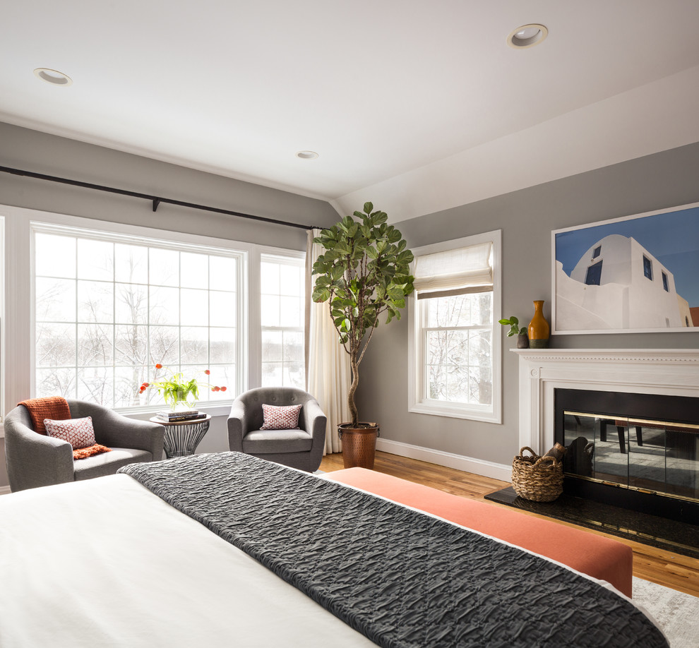 Пример оригинального дизайна: большая хозяйская спальня в стиле неоклассика (современная классика) с серыми стенами, паркетным полом среднего тона, стандартным камином, фасадом камина из камня и серым полом