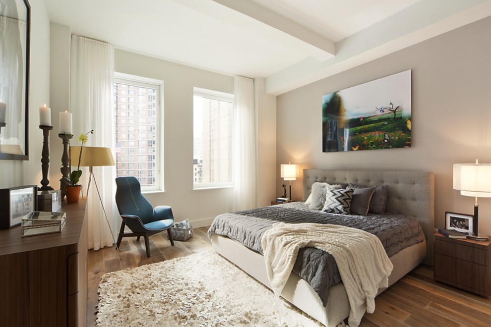 This is an example of a medium sized contemporary master bedroom in New York with white walls and medium hardwood flooring.