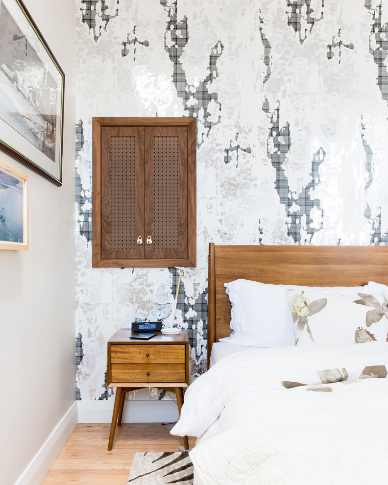 ニューヨークにあるミッドセンチュリースタイルのおしゃれな寝室 (白い壁、淡色無垢フローリング、アクセントウォール) のインテリア