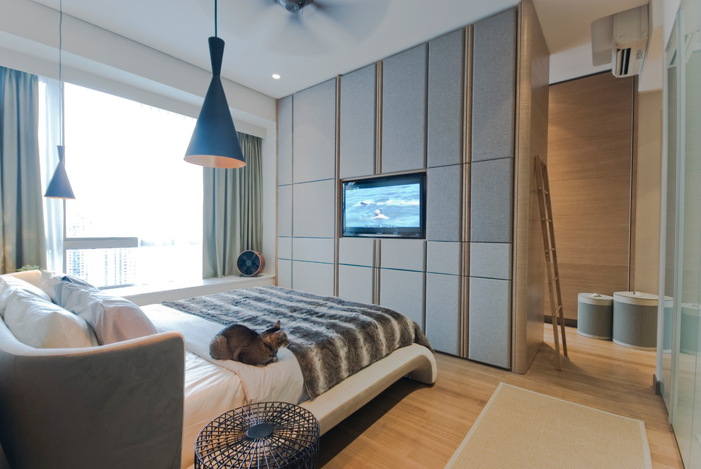Пример оригинального дизайна: спальня в современном стиле с светлым паркетным полом и телевизором