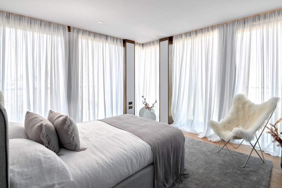 На фото: маленькая гостевая спальня (комната для гостей) в стиле модернизм с серыми стенами и светлым паркетным полом для на участке и в саду с